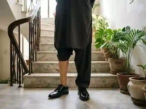 Prosthetic leg and leather shoes at the foot of a staircase at home