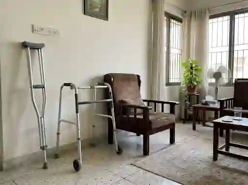 Walker and crutches beside a firm chair at home